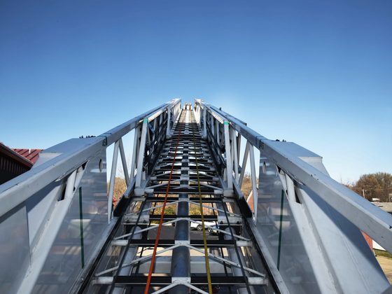 Looking up an extended aerial ladder against the sky